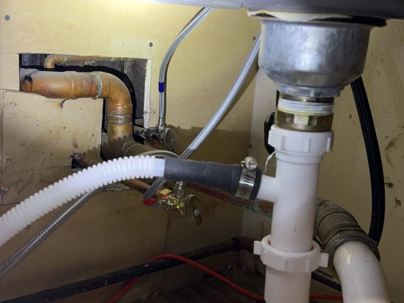 A dishwasher drain hose run flat under the sink, not carried up to the underside of the counter.