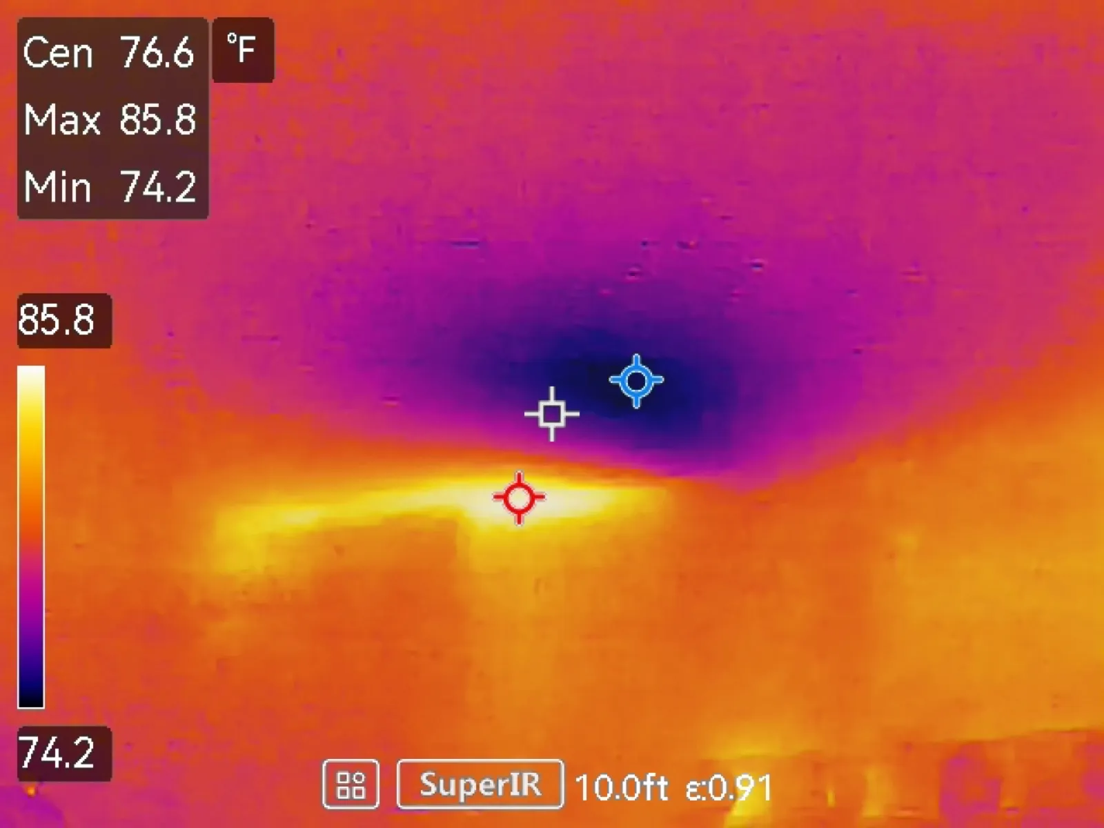 Thermal image of a bathroom ceiling with a dark cool area above a brighter, warmer band lower in the frame